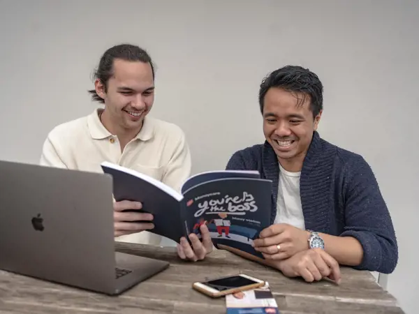 Two men reading a magazine